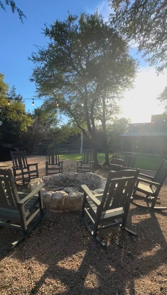 Fire pit with rocking chairs at Willow Sky Ranch on Willow City Loop near Fredericksburg, TX — guests gathering around the outdoor fire after a fall wedding reception at this Texas Hill Country wedding venue